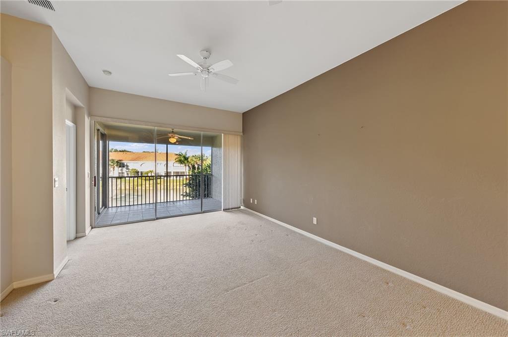 23810 Costa Del Sol Road, Unit 203 Estero, FL 34135 - Photo 13 of 48 Spare room featuring carpet flooring, ceiling fan, and a sunroom
