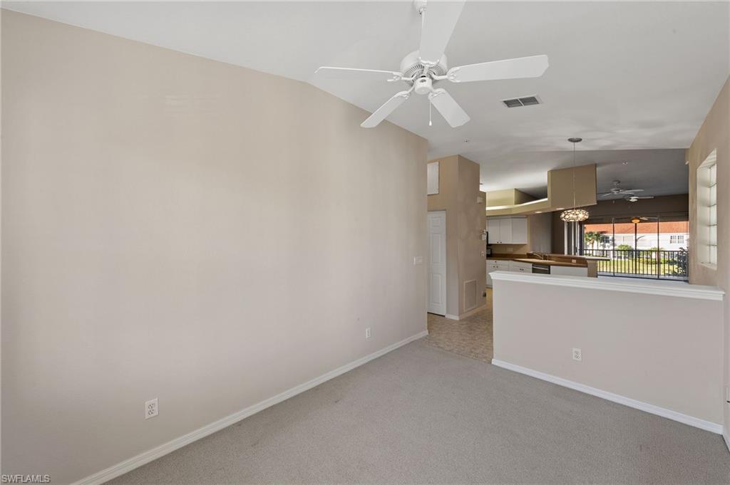 23810 Costa Del Sol Road, Unit 203 Estero, FL 34135 - Photo 15 of 48 Unfurnished room featuring lofted ceiling, light carpet, and ceiling fan