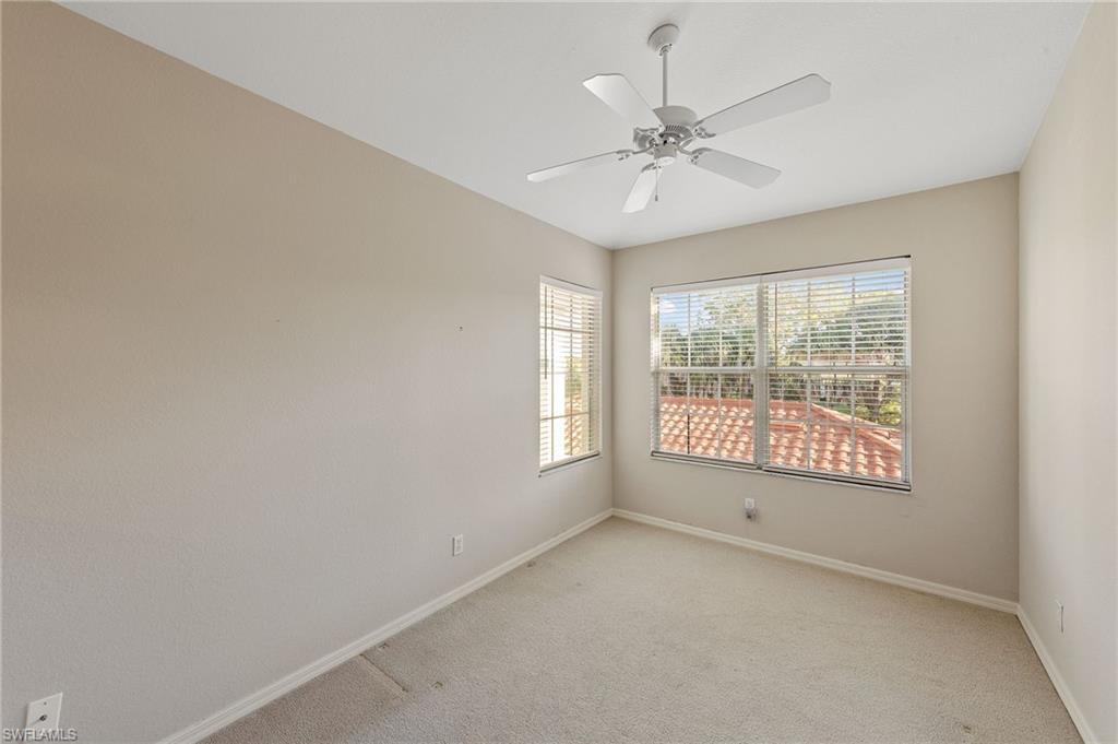 23810 Costa Del Sol Road, Unit 203 Estero, FL 34135 - Photo 17 of 48 Carpeted empty room with baseboards and a ceiling fan