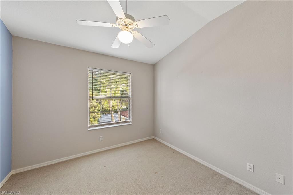 23810 Costa Del Sol Road, Unit 203 Estero, FL 34135 - Photo 18 of 48 Carpeted spare room with vaulted ceiling and a ceiling fan