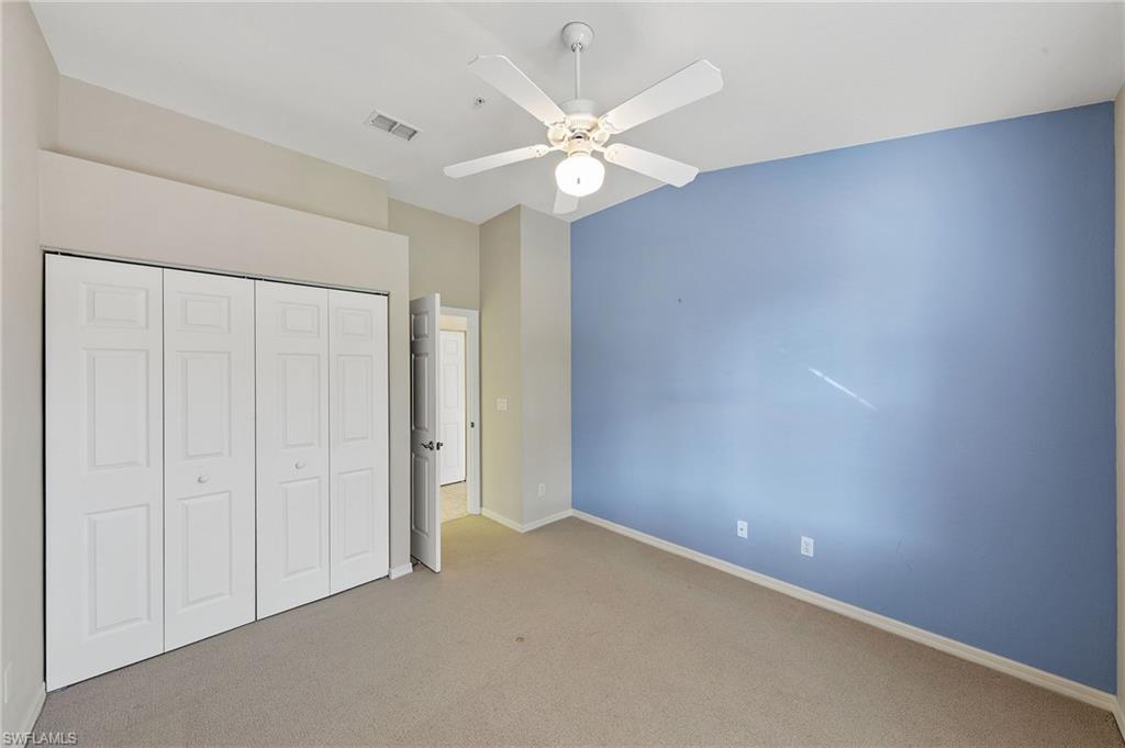 23810 Costa Del Sol Road, Unit 203 Estero, FL 34135 - Photo 19 of 48 Unfurnished bedroom with carpet flooring, a closet, and ceiling fan