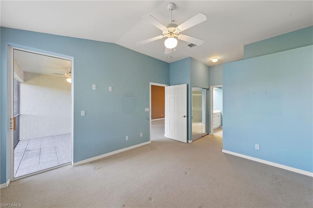 23810 Costa Del Sol Road, Unit 203 Estero, FL 34135 - Photo 23 of 48 Unfurnished bedroom with carpet floors, lofted ceiling, connected bathroom, a ceiling fan, and a closet