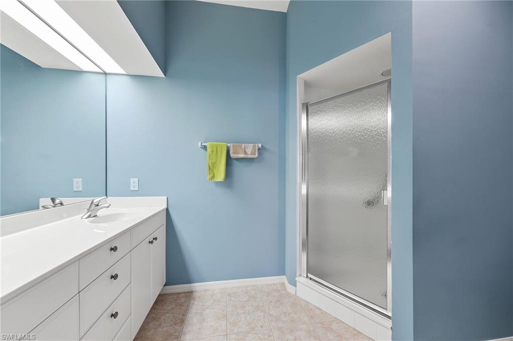 23810 Costa Del Sol Road, Unit 203 Estero, FL 34135 - Photo 25 of 48 Full bath featuring vanity, a stall shower, and light tile patterned floors