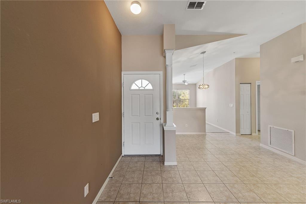 23810 Costa Del Sol Road, Unit 203 Estero, FL 34135 - Photo 4 of 48 Entrance foyer featuring a ceiling fan, ornate columns, light tile patterned floors, and vaulted ceiling