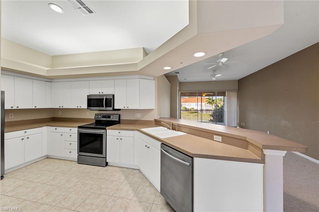 23810 Costa Del Sol Road, Unit 203 Estero, FL 34135 - Photo 7 of 48 Kitchen featuring a peninsula, stainless steel appliances, white cabinets, a ceiling fan, and recessed lighting