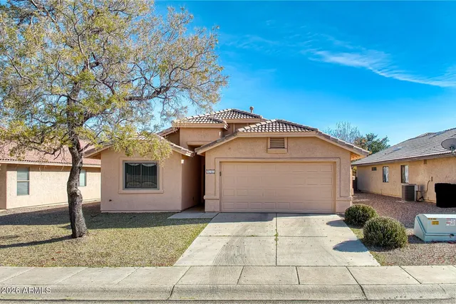 a view of a white house with a yard and large tree
