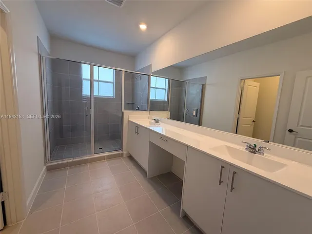 a spacious bathroom with a double vanity sink mirror and double
