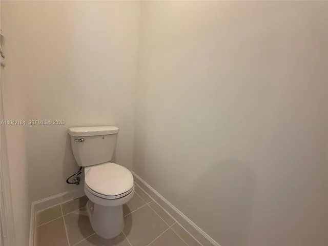 a white toilet sitting next to a white wall