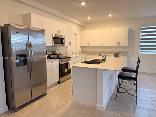 a kitchen with a refrigerator stove top oven and sink