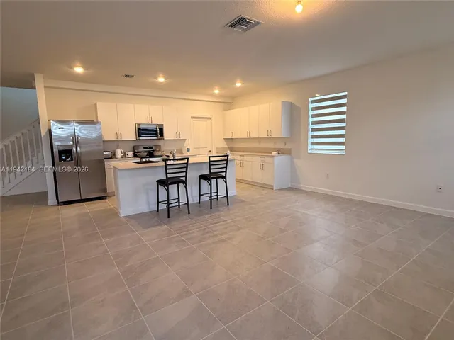 a large white kitchen with a large window