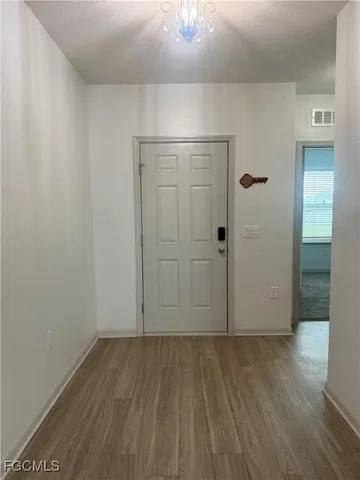 a kitchen with kitchen island granite countertop a stove top oven a sink dishwasher and a refrigerator with wooden floor