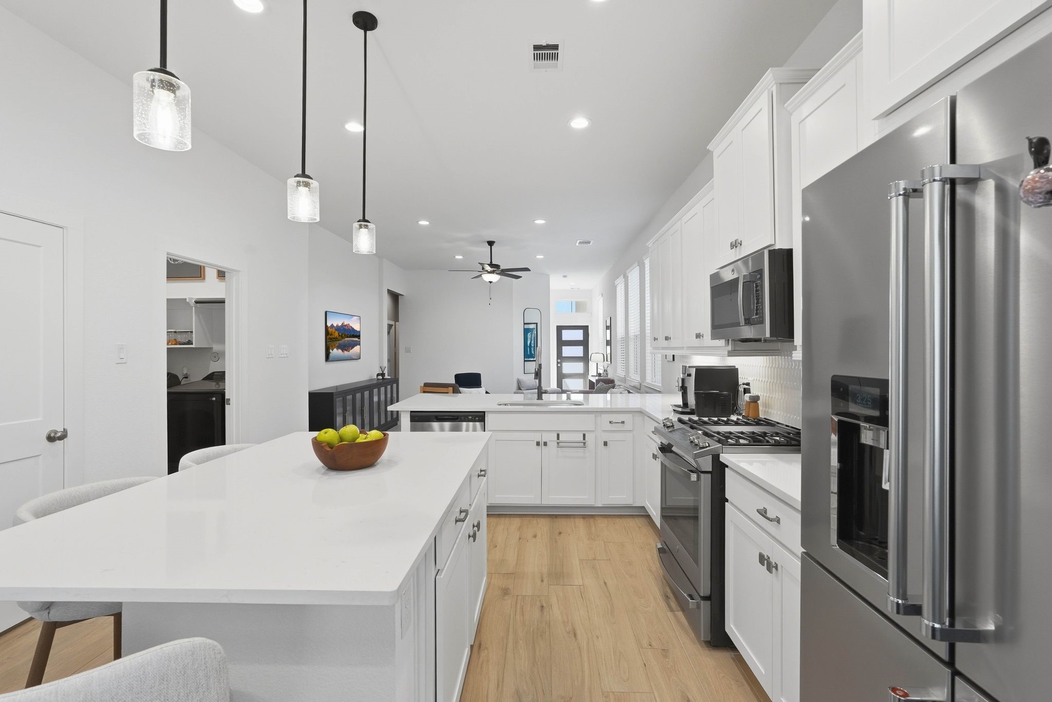 17907 Purple Amaranth Conroe, TX 77385 - Photo 13 of 30 a kitchen with a refrigerator a stove and white cabinets with wooden floor