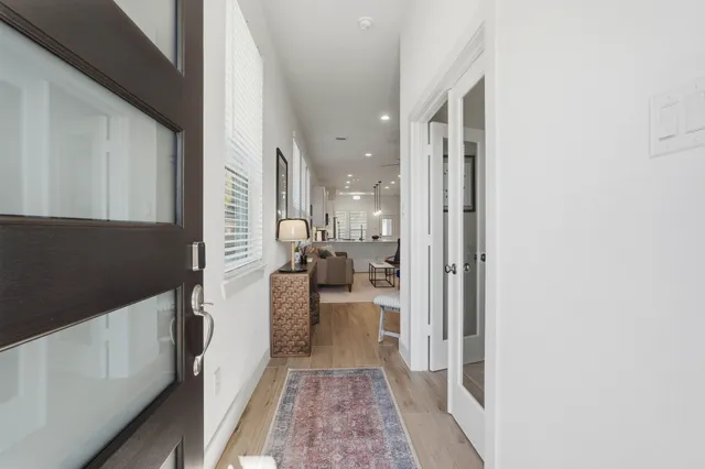 a walk in closet with wooden floor