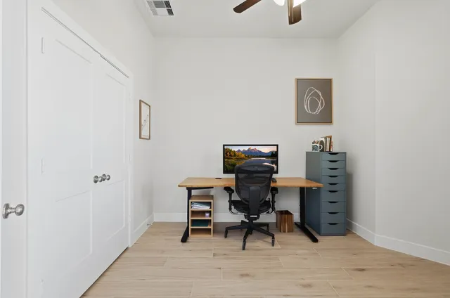 a view of a workspace with furniture and a window