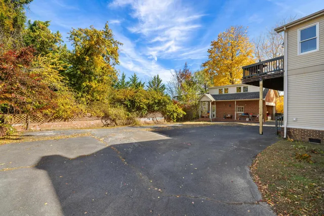 a view of a house with a yard and large tree
