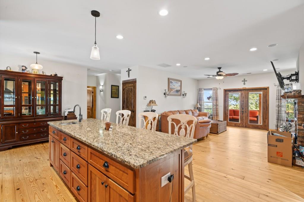 1688 Mulberry Circle Jasper, GA 30143 - Photo 16 of 90 a large kitchen with kitchen island a stove a sink a dining table and chairs with wooden floor