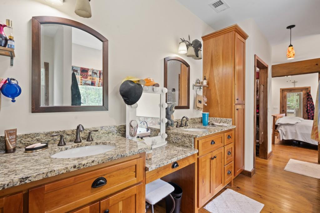1688 Mulberry Circle Jasper, GA 30143 - Photo 33 of 90 a bathroom with a granite countertop sink a mirror and shower