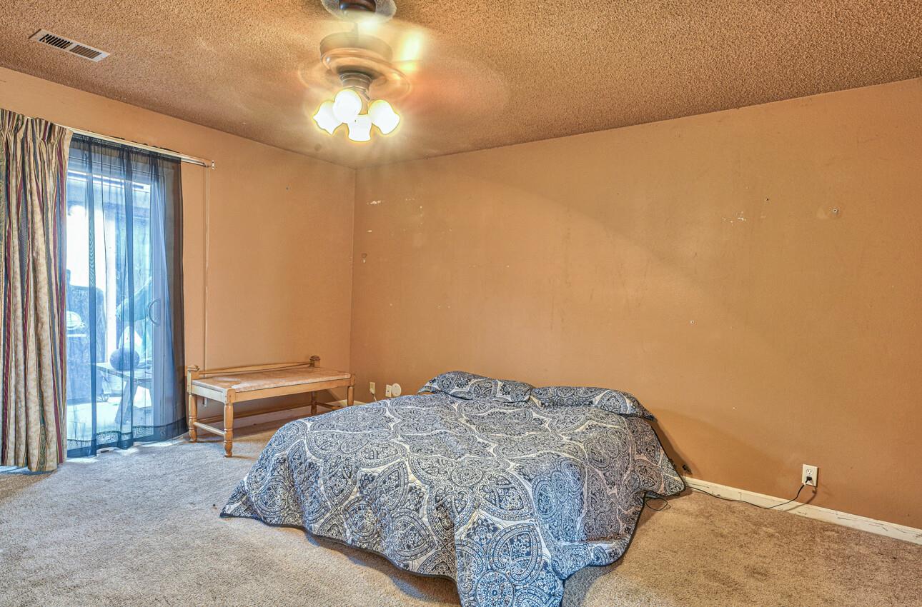 19682 Rogge Road Salinas, CA 93906 - Photo 15 of 22 a bedroom with a bed and a chandelier fan