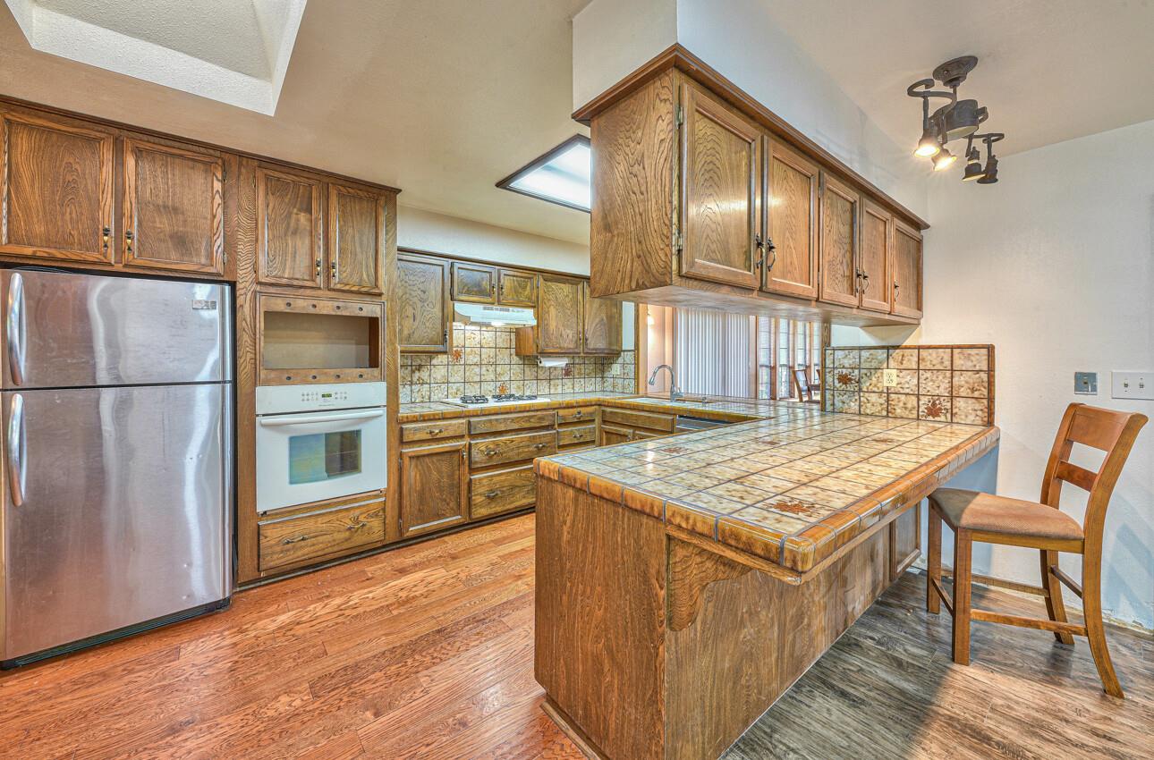 19682 Rogge Road Salinas, CA 93906 - Photo 9 of 22 a kitchen with stainless steel appliances granite countertop a stove a refrigerator a sink dishwasher and wooden cabinets with wooden floor