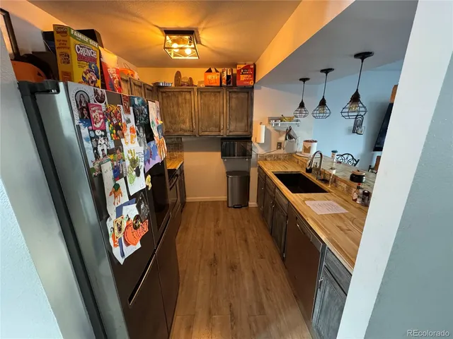 a view of a kitchen with fridge and sink