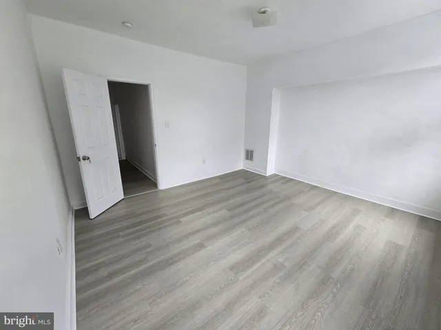 wooden floor in an empty room with a window