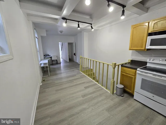 a view of a hallway with wooden floor and workspace