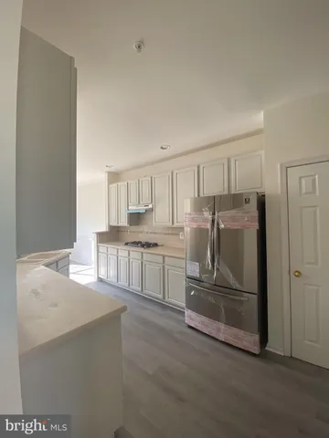 a kitchen with stainless steel appliances granite countertop a refrigerator and a stove