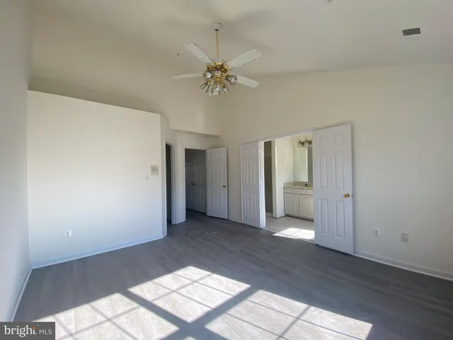 a view of a big room with wooden floor and windows