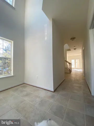 a view of a hallway with closet and a window