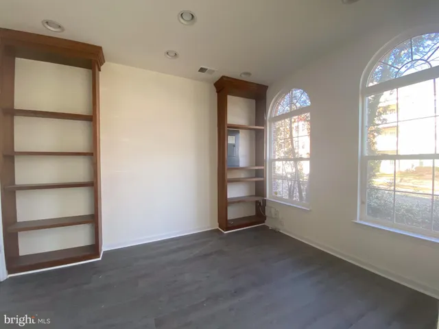 an empty room with windows and closet