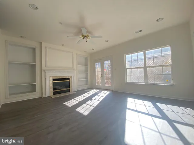 a view of an empty room with a fireplace and a window