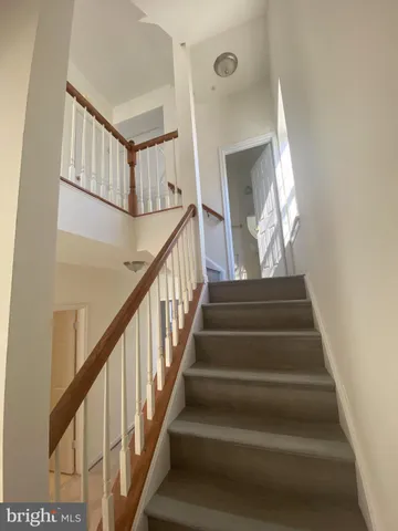a view of staircase with white walls and a window