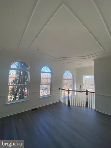 a view of empty room with wooden floor and windows