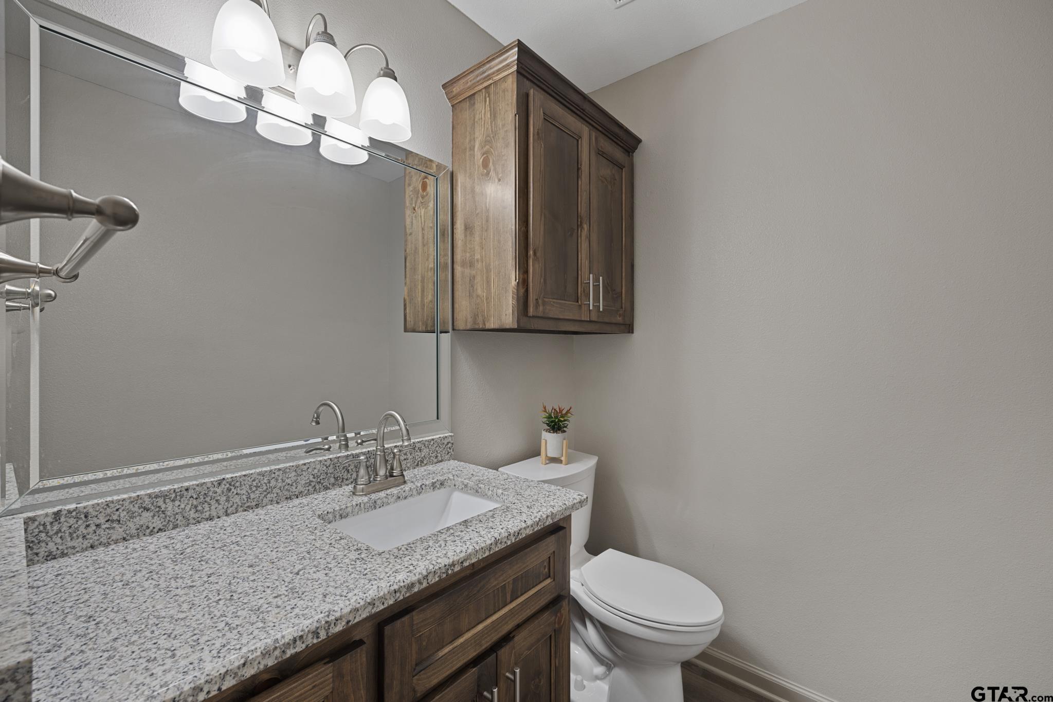 2201 Ridgley Tyler, TX 75703 - Photo 28 of 42 a bathroom with a granite countertop sink a toilet and a mirror