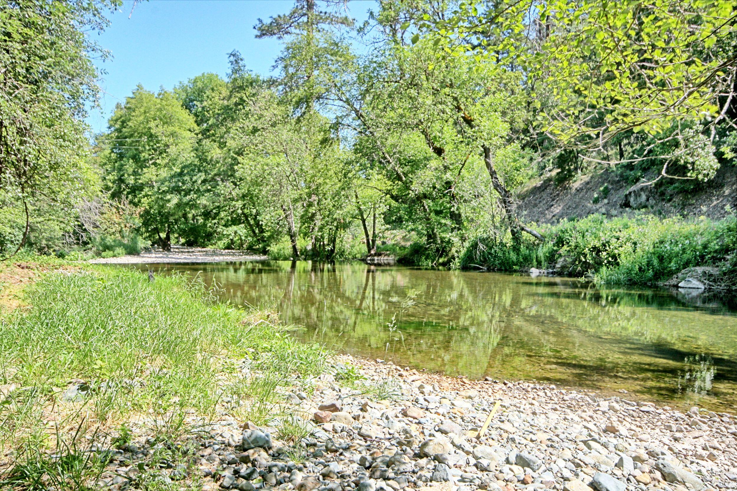 199 Powell Creek Road Williams, OR 97544 - Photo 6 of 57 a backyard of a house with lots of green space and lake view