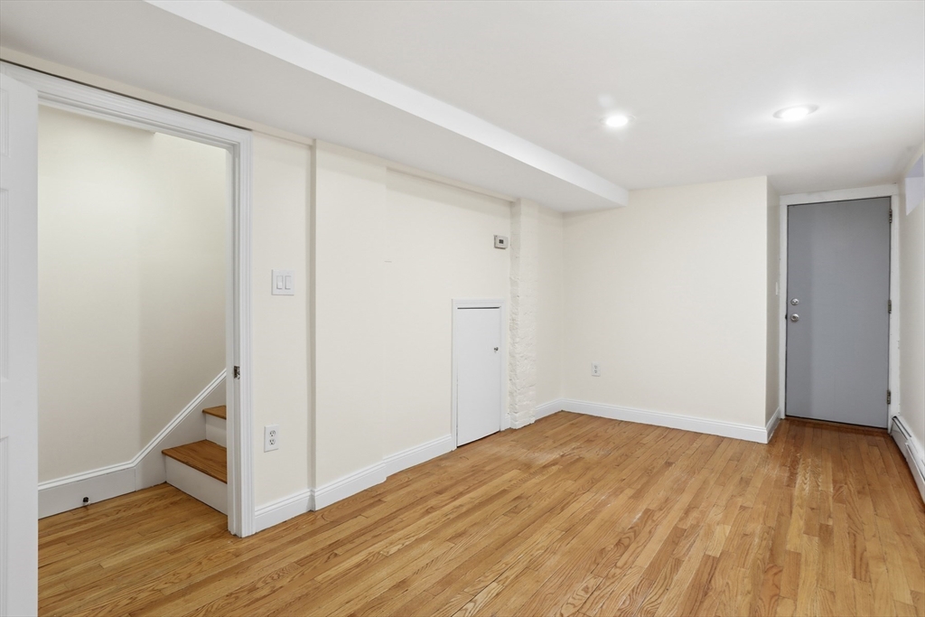 13 Howard Street, Unit 1 Cambridge, MA 02139 - Photo 13 of 21 a view of an empty room with wooden floor and a window