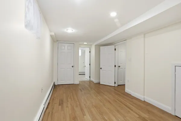 a view of a big room with wooden floor and windows