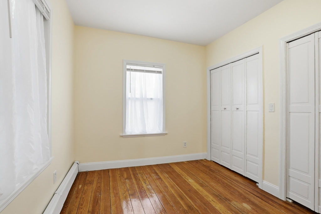 13 Howard Street, Unit 1 Cambridge, MA 02139 - Photo 9 of 21 an empty room with wooden floor and windows