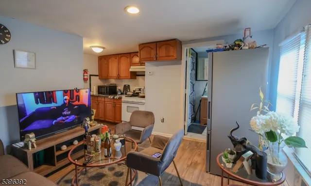 a living room with furniture and a dining table with wooden floor