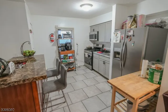 a kitchen with stainless steel appliances granite countertop a refrigerator and a stove