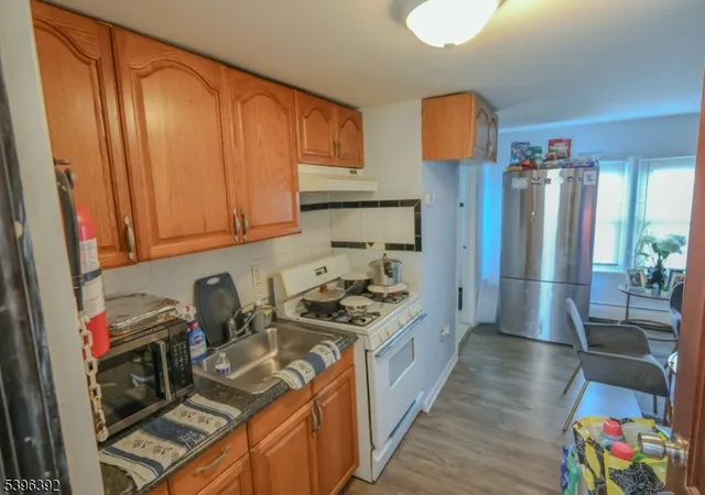 a kitchen with stainless steel appliances granite countertop a stove a refrigerator and a wooden cabinets