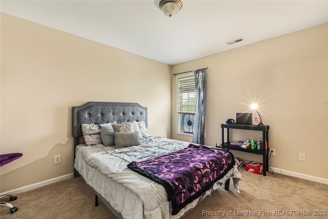 10 Pender Road Spring Lake, NC 28390 - Photo 20 of 23 a bedroom with a bed and a lamp on table