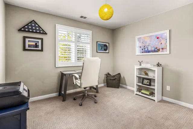 a view of a workspace with furniture and a window