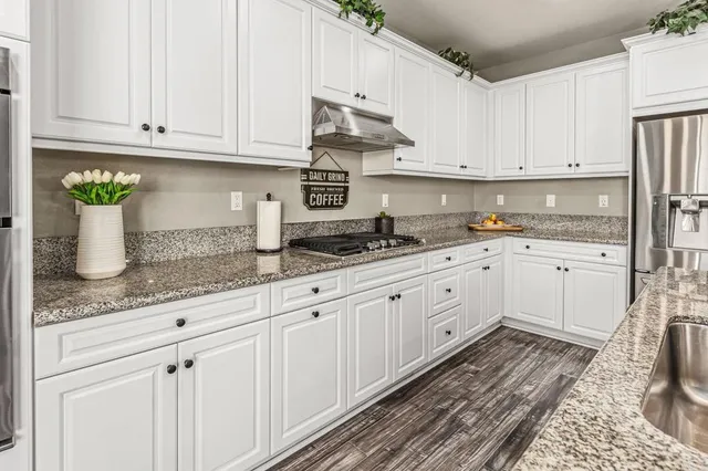 a kitchen with granite countertop white cabinets and white appliances