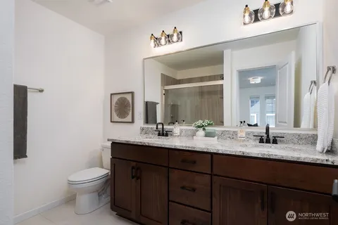 a bathroom with a double vanity sink toilet and a mirror
