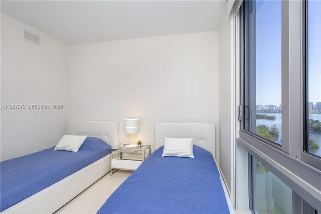a bedroom with a bed and flat tv screen on the dresser