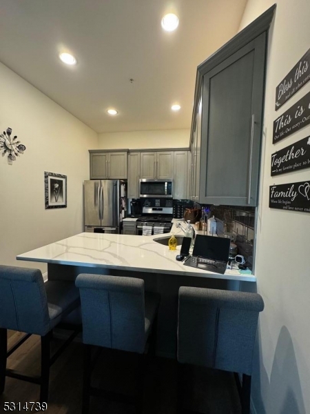 183 Garibaldi Avenue, Unit 207 Lodi, NJ 07644 - Photo 4 of 10 a kitchen with kitchen island appliances cabinets and furniture