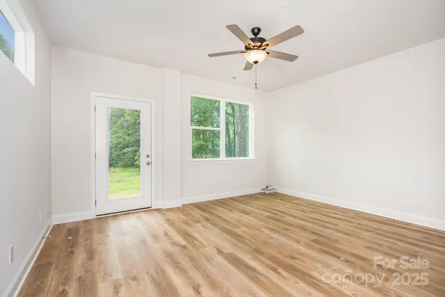 an empty room with a window and a fan