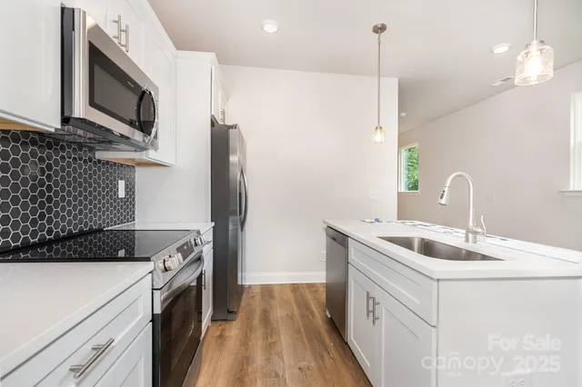 a kitchen that has a sink a microwave oven a refrigerator and a stove