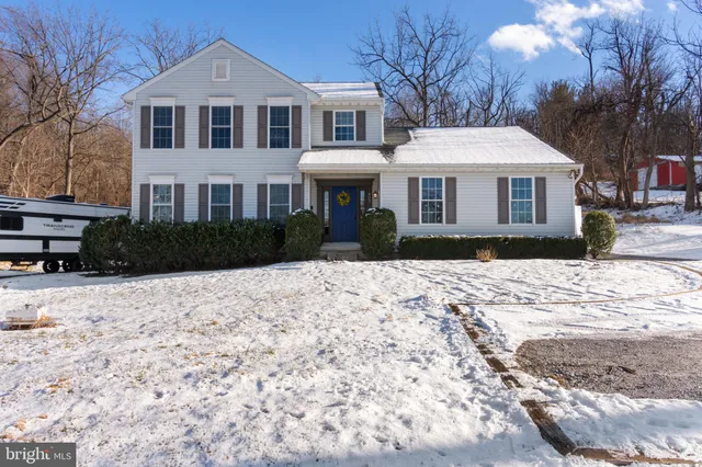 a front view of a house with a yard covered in snow